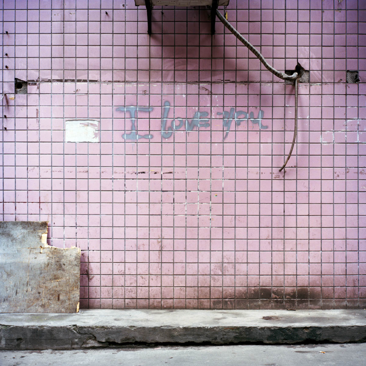 Jia Yue - Yue just started working a the Metropolitain Art Salon. Her main job is washing hair. Her employee does not want us to visit the dormitory where Yue lives, not far from the salon. She points out this pink-tiled building. Chengdu, Sichuan Province, China, April 2012. - Copyright © © S. Borcard - N. Metraux - Chengdu - Sichuan Province - China - <A href="https://maps.google.com/?ll=30.662428,104.066055&z=16" target="_blank">(Map Jia Yue)</A>