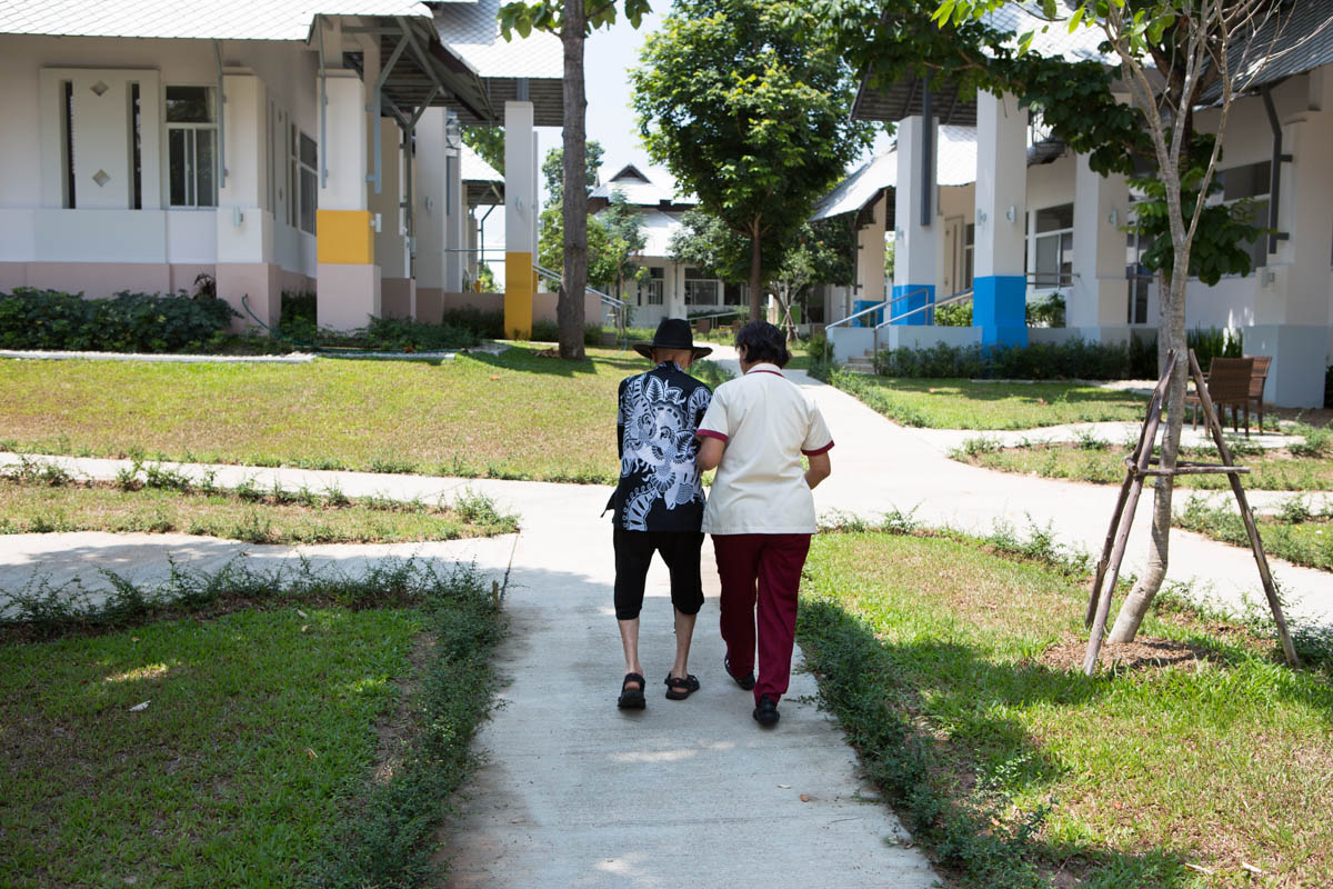 Paul and Sassinee - Paul, 85, and Sassinee, 58, on their way to the main building. Doi Saket, Chiang Mai, Thailand, May 2015. - Copyright © © S. Borcard - N. Metraux - Doi Saket - Chiang Mai - Thailand - <A href="https://maps.google.com/?ll=18.90072,99.140313&z=16" target="_blank">(Map Paul and Sassinee)</A>