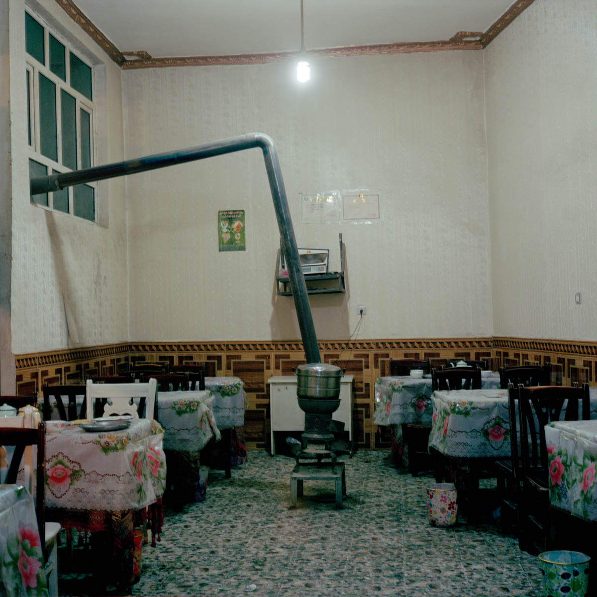 Interior of a lamb and noodles restaurant - Interior of a lamb and noodles restaurant. A stove has been installed to warm the place. Hotan, Xinjiang, China 2012.