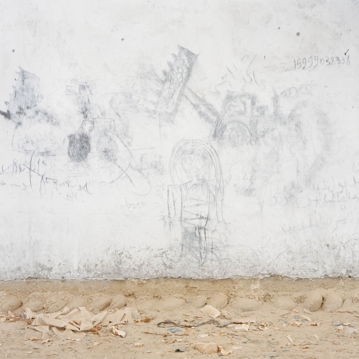 Children's drawing - Children's drawing on a wall representing caterpillars. The demolition of the old part of many Uyghur cities has begun, making place to new concrete blocks. Due to it's remoteness, Hotan is one of the lesser touched cities by this developpement. Hotan, Xinjiang, China 2012.