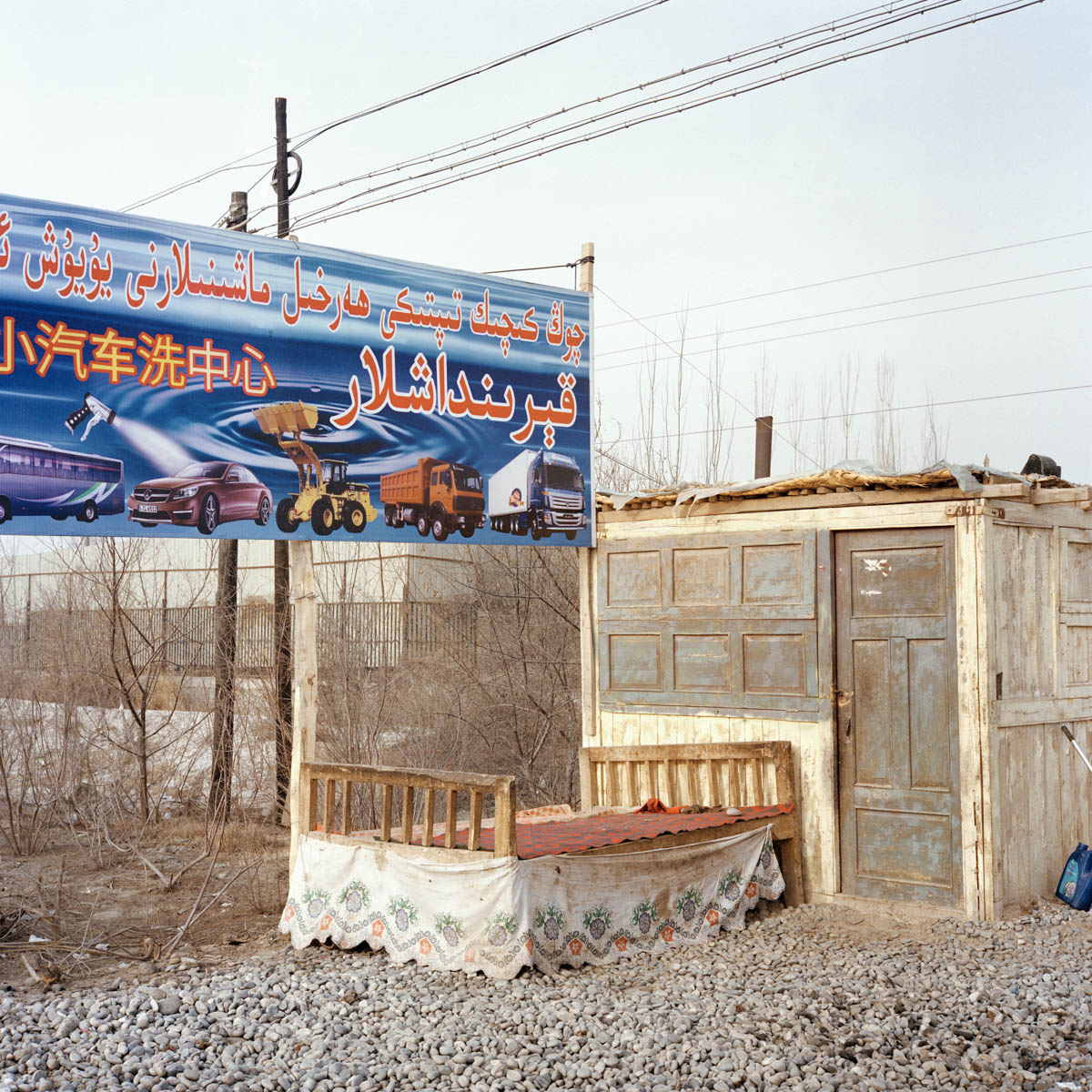 Roadside hut - Roadside hut and advertisement board for caterpillars trucks and cars. A flagrant contrast beween, the ancient times and the modern ones. Hotan, Xinjiang, China 2012.