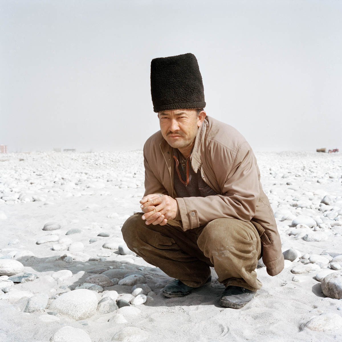 Uyghur jade miner - Uyghur jade miner in the Hotan River bed. Every day, hundreds of locals gather in the riverbed hunting for jade.  Hotan, Xinjiang, China 2012.