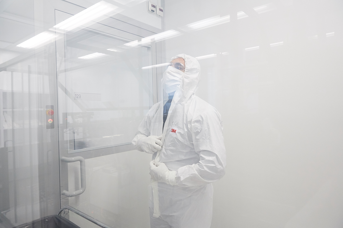 Sina Abdolhosseinzadeh, 32, from Teheran dressing up a white smock gloves, face mask and goggles. The clean room where the enormous printer is, must stay absolutely dust free in order to achieve a maximum printing precision. EMPA, Dübendorf, October 2018.