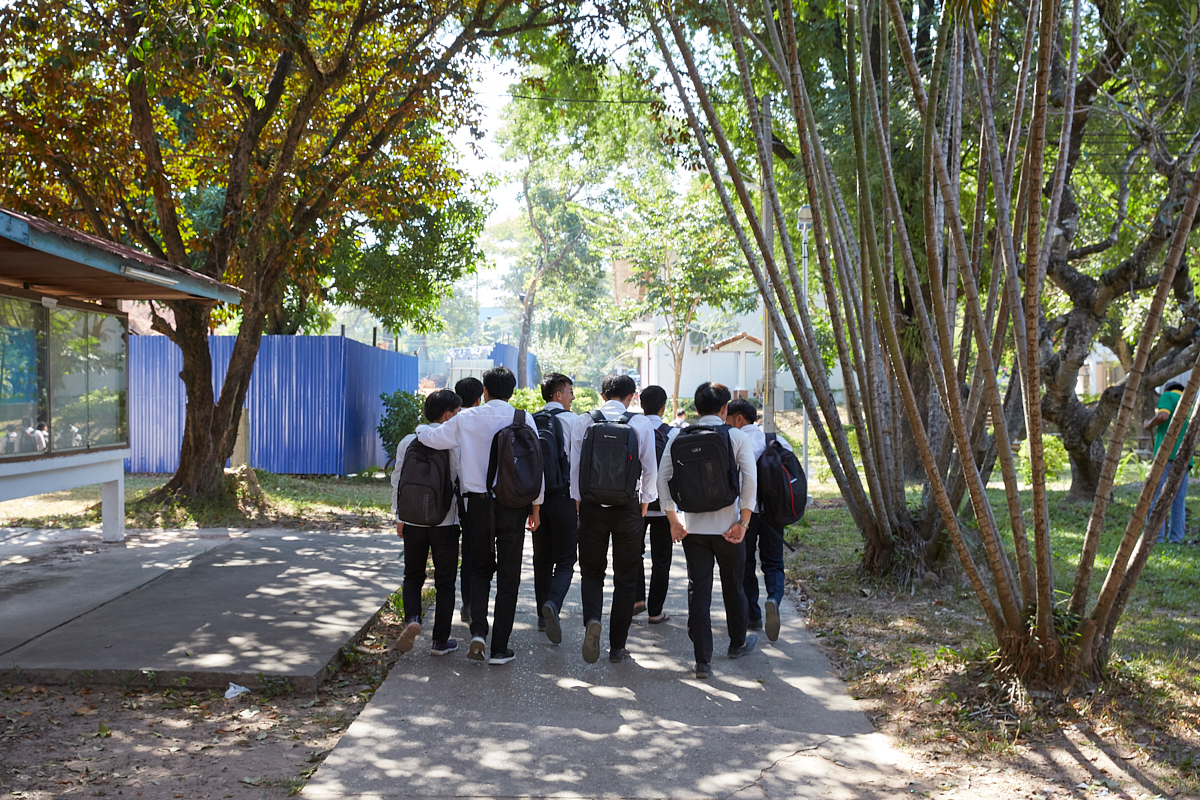 Students walking in the shade of trees at the University of Laos engineering campus. Vientiane, Laos, November 2018.